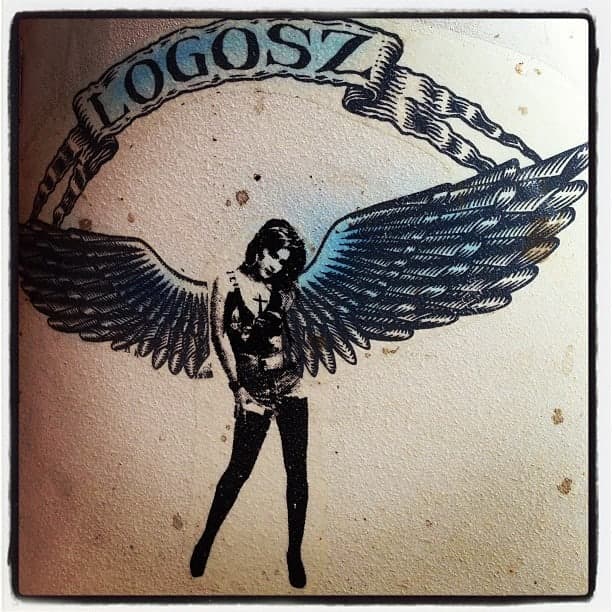 The Logosz mark — a winged figure under a banner reading LOGOSZ, printed on a weathered board