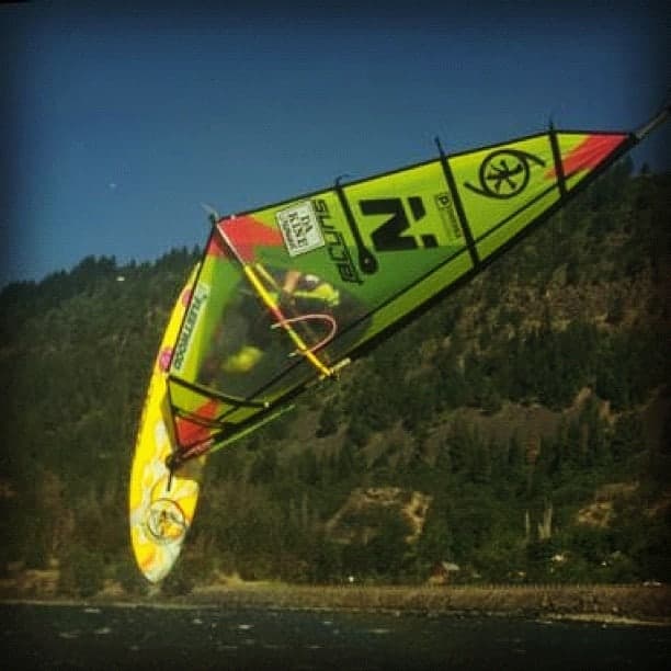 A windsurfer inverted mid-loop above the Columbia, the Oregon hills behind — from Tony Logosz's archive