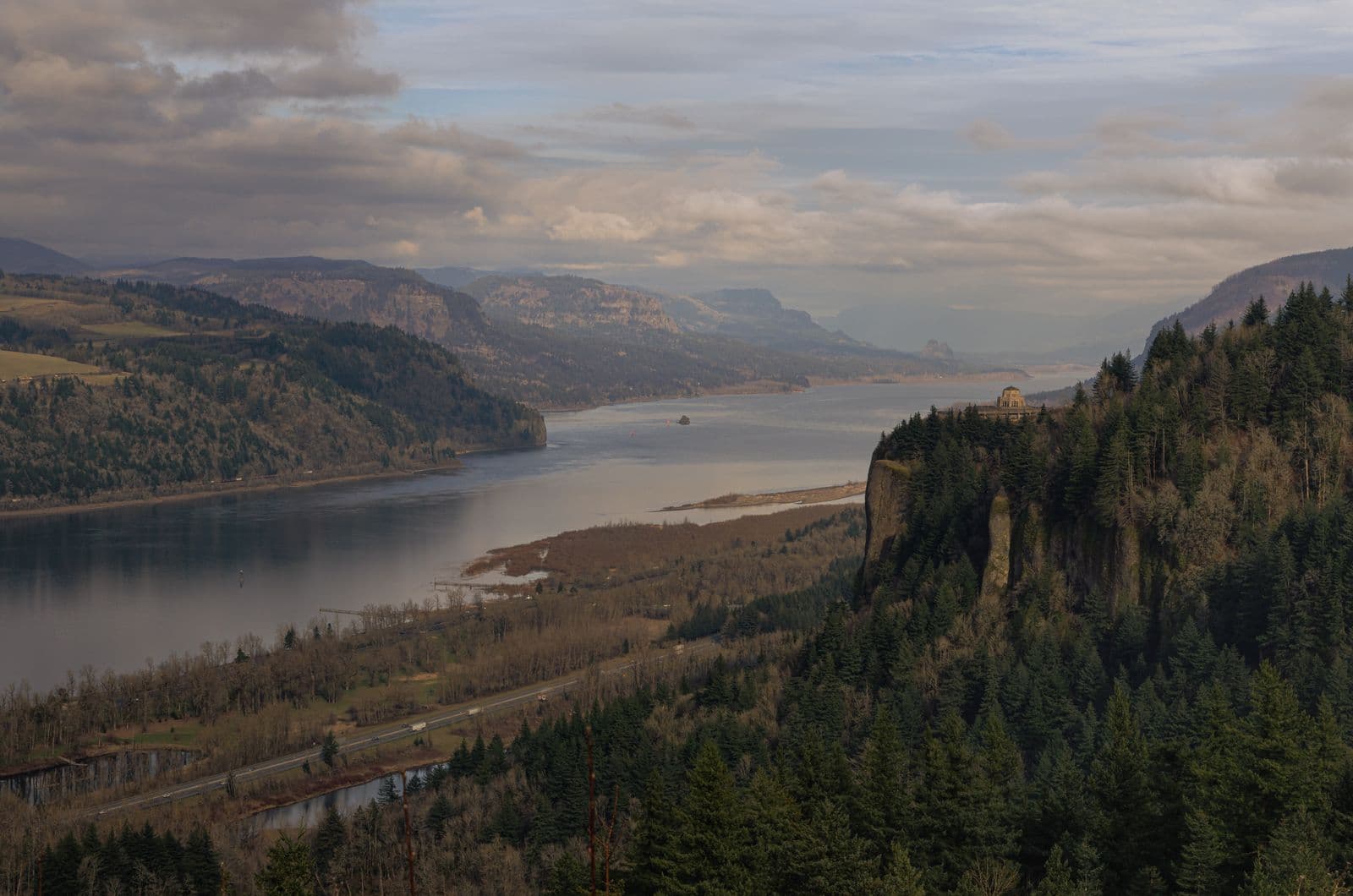 The Columbia River Gorge looking east from Crown Point, the river flat and pale under broken cloud with Vista House on the basalt promontory at right — the stretch of water every one of these designs was tested on