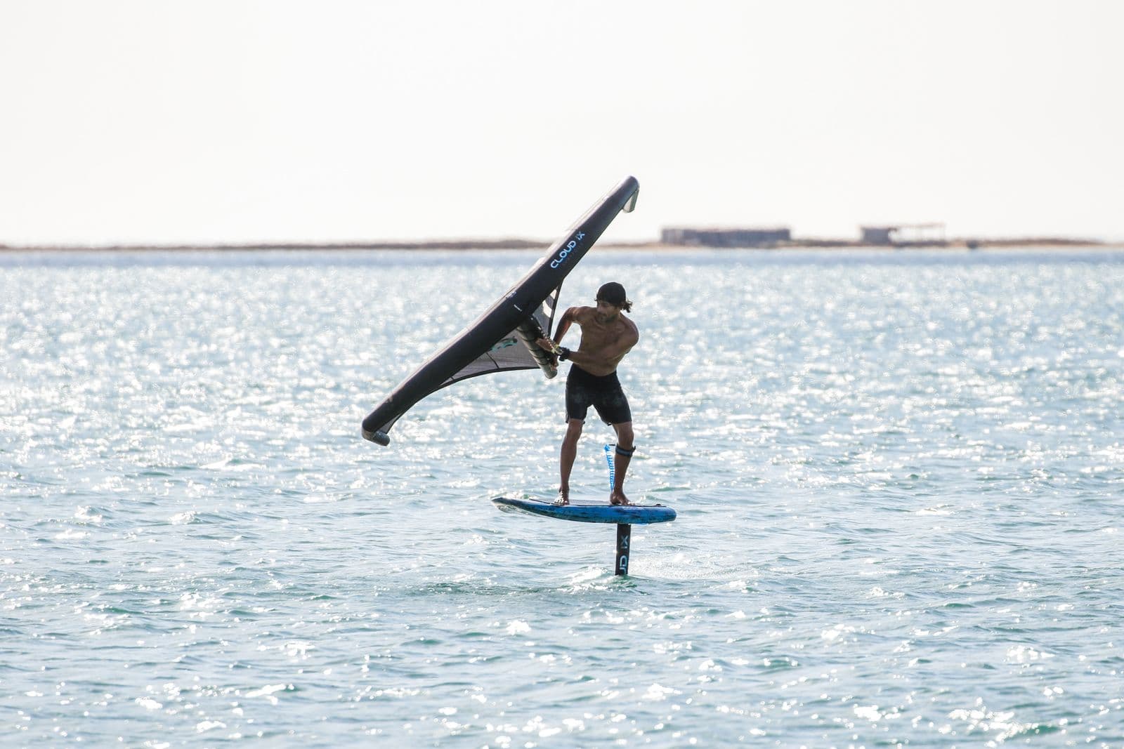 A complete REVSTAR hydrofoil setup laid out on the beach: front wing, mast, fuselage and stabilizer